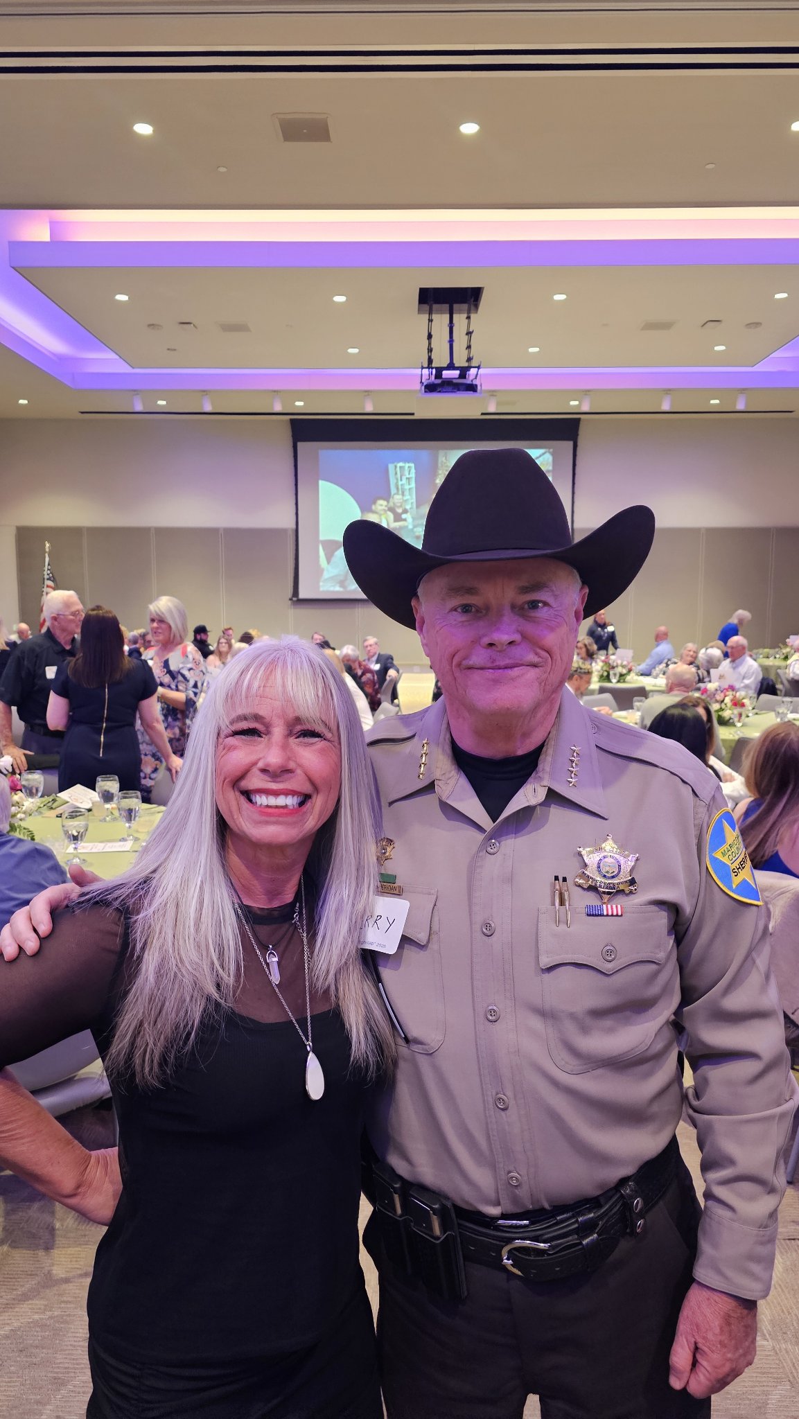 Angel Prater with a uniformed Maricopa County sheriff at a banquet
