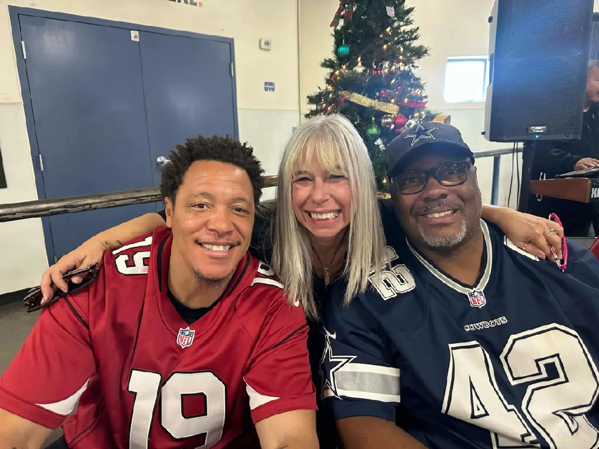 Angel Prater between two players at a Champions for the Homeless event