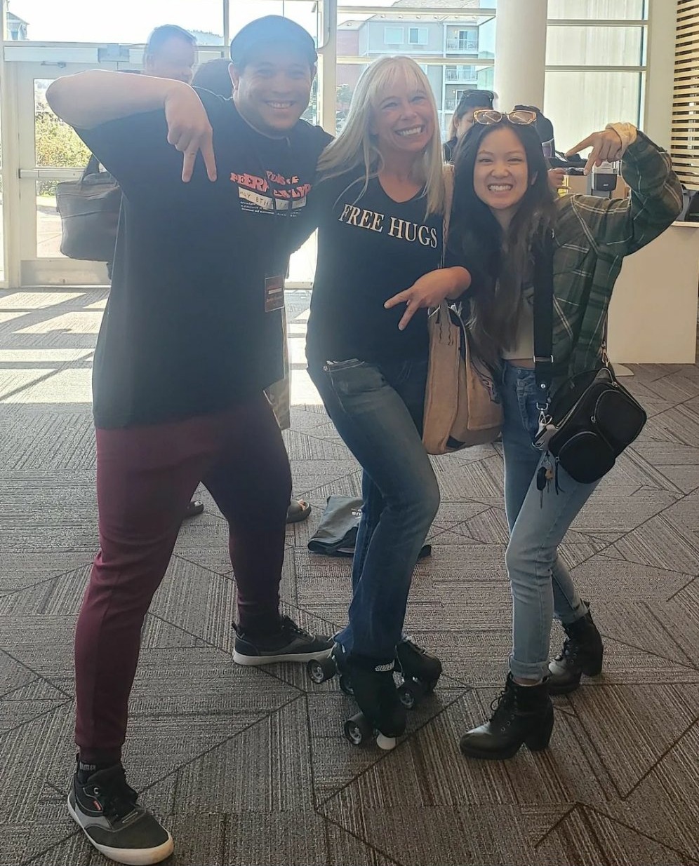 Angel Prater on roller skates in a FREE HUGS shirt with two friends