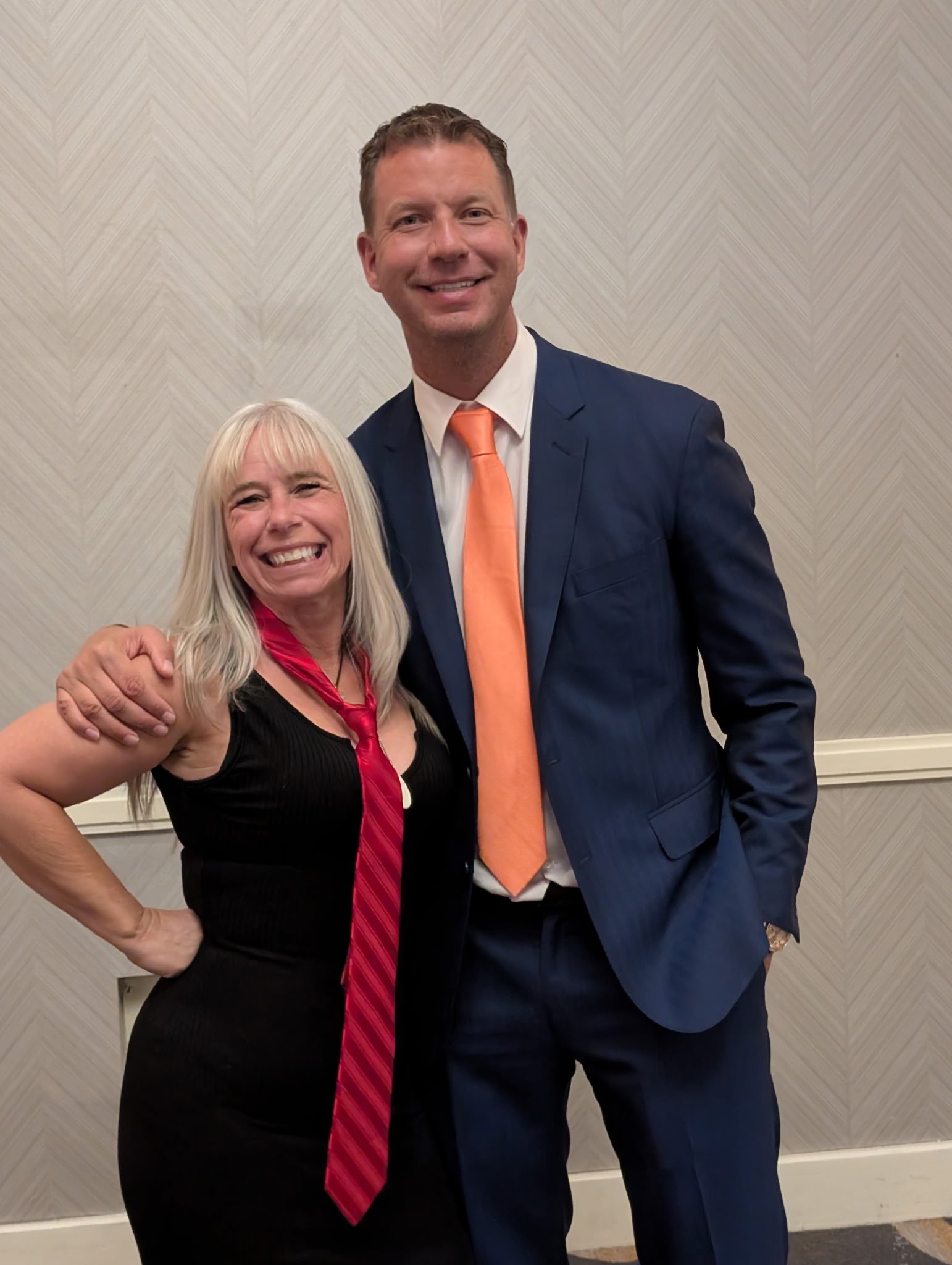 Angel Prater wearing a red tie, standing with JT Foxx