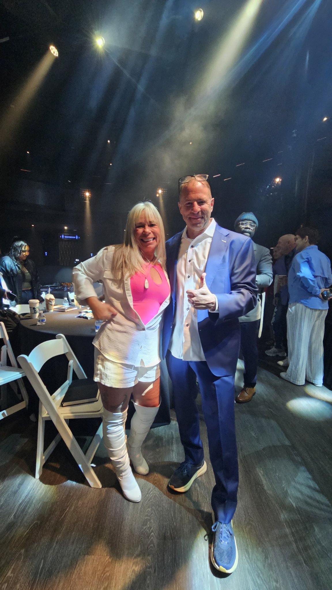 Angel Prater in a pink top and white boots with a fellow guest at Secret Knock