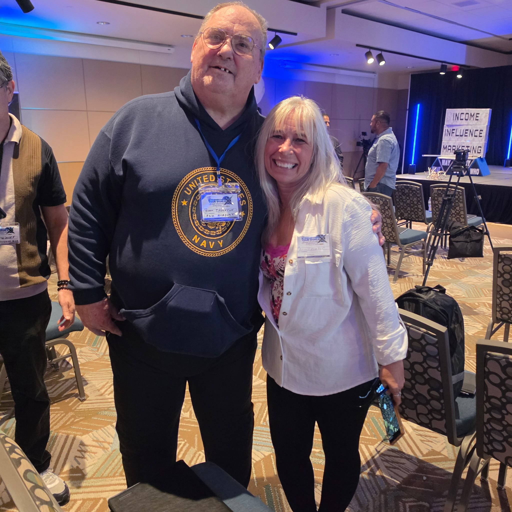 Angel Prater with Dr. Buddy Thornton, wearing a U.S. Navy hoodie, in a conference room