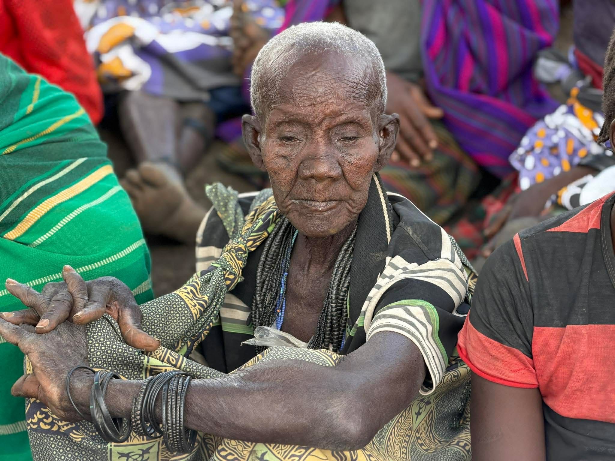 Close portrait of an elderly woman in Uganda with her hands clasped